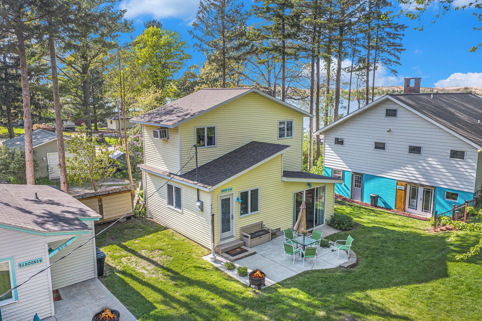A two-story house with a patio, a small deck, and a fire pit.
