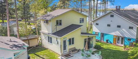 A two-story house with a patio, a small deck, and a fire pit.