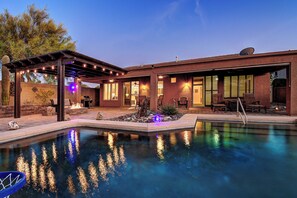 A modern house with a swimming pool, patio, and outdoor seating area. - Anthem Getaway with Backyard Oasis!  (New River)