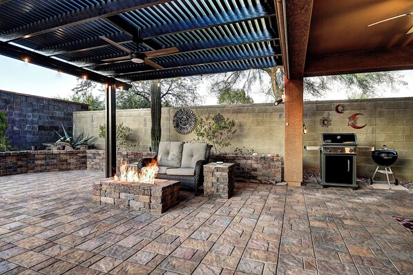 A covered patio with a fire pit, outdoor seating, and a grill. - Anthem Getaway with Backyard Oasis! (New River)
