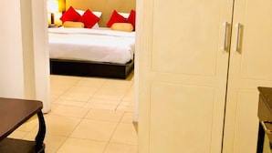 Une chambre d’hôtel avec un lit, une armoire et un bureau.