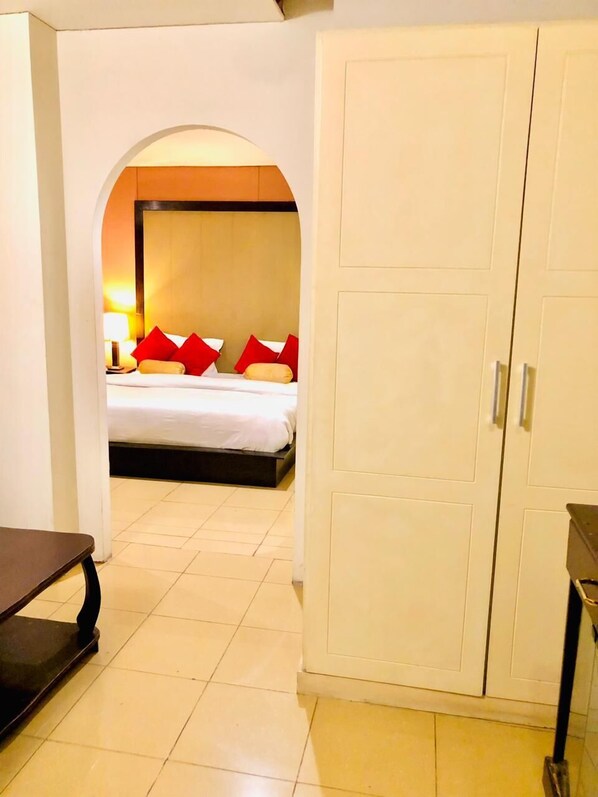 A hotel room with a bed, a wardrobe, and a desk. - Hotel Grand Inn Lahore (Lahore)