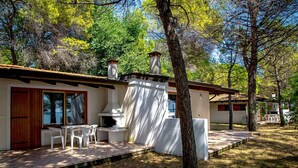A modern house with a patio, outdoor seating, and a chimney.