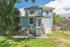 A two-story house with a front porch, a small front yard, and a chain-link fence. - 2 homes that sleep 16! (Hampton)