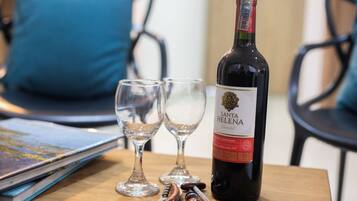 Una botella de vino Santa Helena, dos copas vacías, un sacacorchos y un termómetro sobre una mesa de madera.