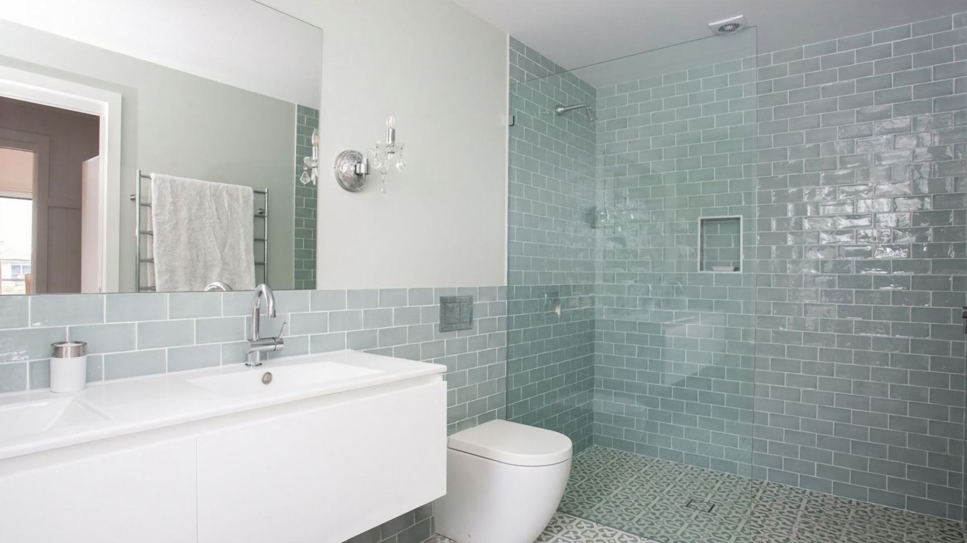 A bathroom with a white sink, a toilet, and a glass shower enclosure.