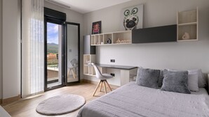 A bedroom with a bed, a desk, and a chair. There is a sliding door leading to a balcony. - Detached House with Landscape Views and Charm in the Heart of the Basque Country (MARKAIDA)