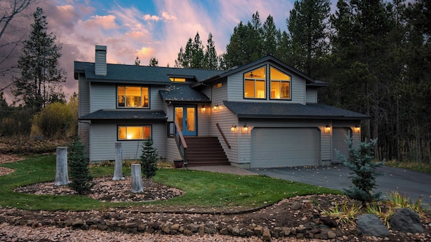 A two-story house with a garage, a covered front porch, and a landscaped front yard. - Private Boat Ramp Access Hot Tub, Fire Pit, Deck River Meadows by Avantstay (Bend)