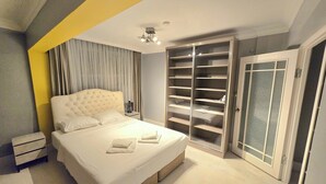Quarto com uma cama grande, um guarda-roupa e uma mesinha de cabeceira.