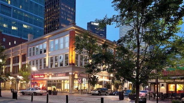 A multi-story building with commercial spaces on the ground floor, including a Chipotle restaurant. - Historic 2BR Loft: Private Terrace & Free UFC Gym (Pittsburgh)