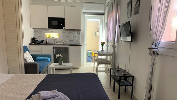 A compact hotel room with a bed, a small kitchenette, a seating area, and a TV. - Mar&mar apartment with solarium and swimming pool. (Gran Tarajal)