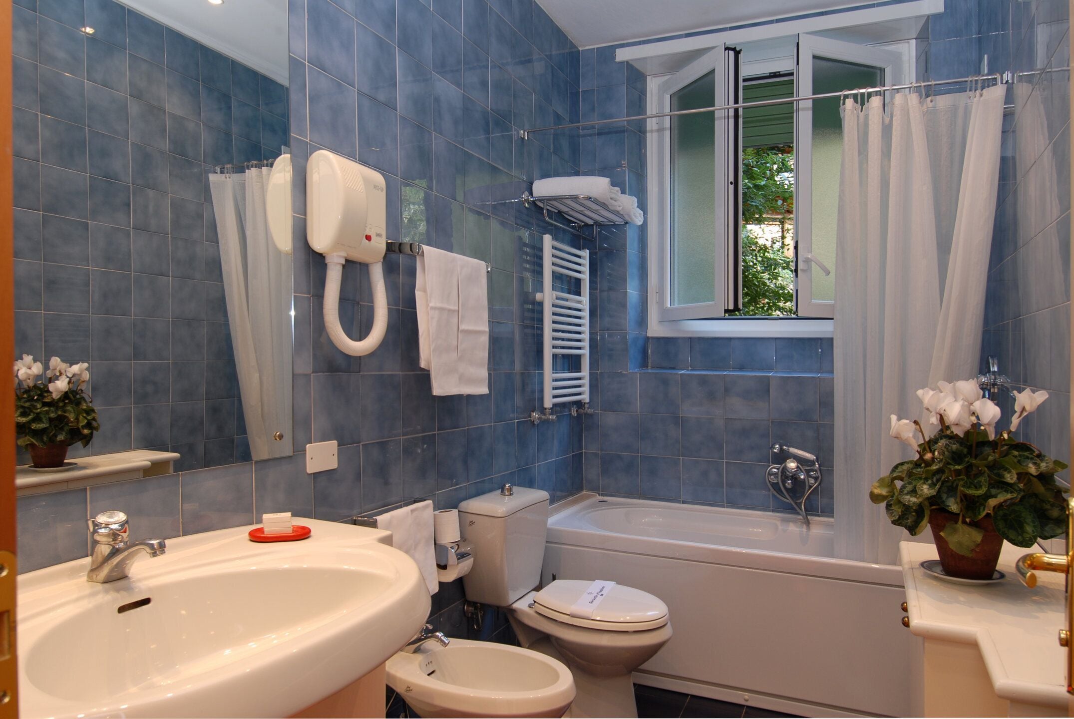 Une salle de bain équipée d’une baignoire, de toilettes, d’un lavabo et d’une douche.