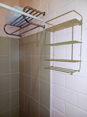 A cozy retreat features a brick wall, a tiled floor, and a metal towel rack with a towel.