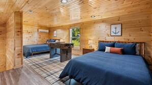 Une chambre dans un chalet en bois, avec un lit, un bureau et une chaise.