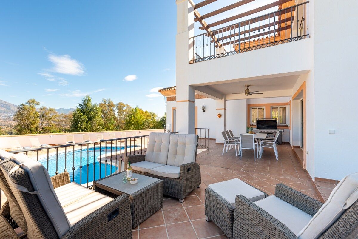 A rooftop terrace with outdoor furniture, a pool, and a kitchen area.