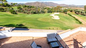 A golf course with a patio area featuring outdoor seating and a view of the surrounding landscape. - Villa Amland | Golf Paradise with private swimming pool (Mijas)