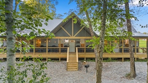 A wooden building with a covered porch and a staircase leading to the entrance.