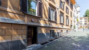 A cobblestone street with historic buildings, a metal gate, and a clear sky. - Luxurious home of the antiquarian at Spanish Steps (Rome)