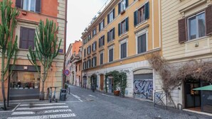 A street with buildings, a crosswalk, and a no parking sign.