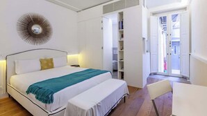 A bedroom with a bed, bedside tables, a wardrobe, and a chair.
