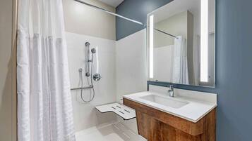 Un baño moderno con ducha, lavabo y espejo.