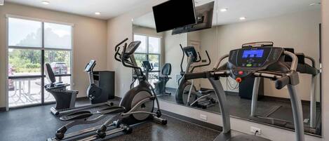 A gym with treadmills, elliptical machines, and a stationary bike.