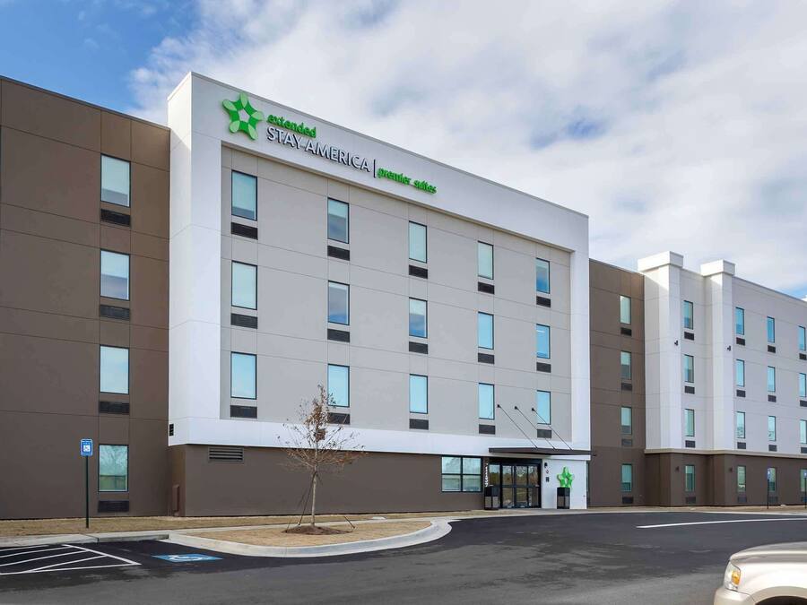 A Stay America Premier Suites hotel with a modern facade, multiple windows, and a parking lot.