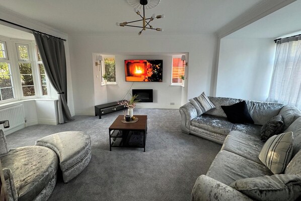A living room with a fireplace, a sofa, a coffee table, and a television.