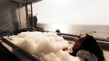 Guests can unwind in a bathtub by the window overlooking the water.