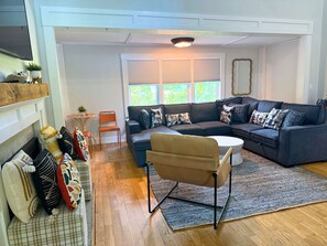 A modern living room with a sectional sofa, a small table, and a chair.