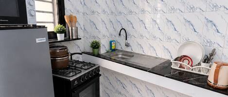 A kitchen with a stove, oven, microwave, and sink.