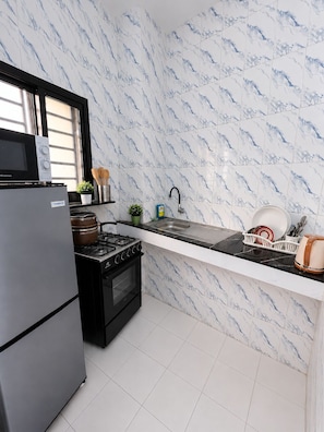 A kitchen with a stove, oven, microwave, and sink.
