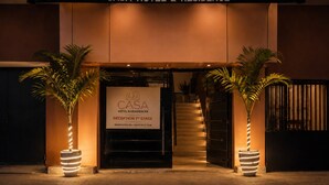 L’entrée de l’hôtel-résidence Casa se compose d’un comptoir d’accueil, de deux plantes en pot et d’un escalier menant à l’entrée principale.