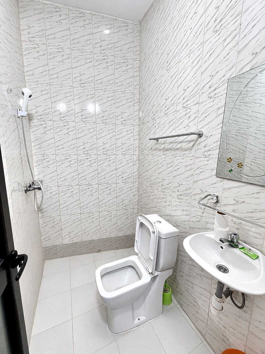 Een badkamer met toilet, bidet, douche en wastafel.