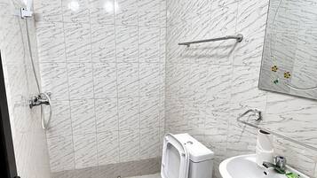 Een badkamer met toilet, bidet, douche en wastafel.