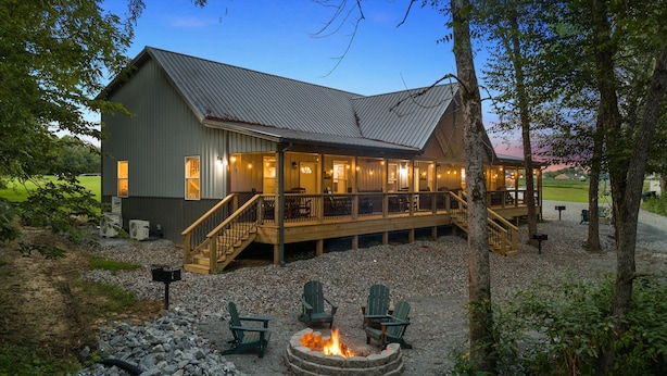 Eine Lodge mit überdachter Terrasse, Sitzgelegenheiten im Freien und einem Feuerkorb.