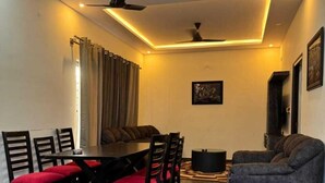 Un coin repas avec une table et des chaises, un canapé et un ventilateur de plafond.