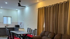 Un salon moderne avec un canapé, une table basse en verre et un coin repas comprenant des chaises et une table.
