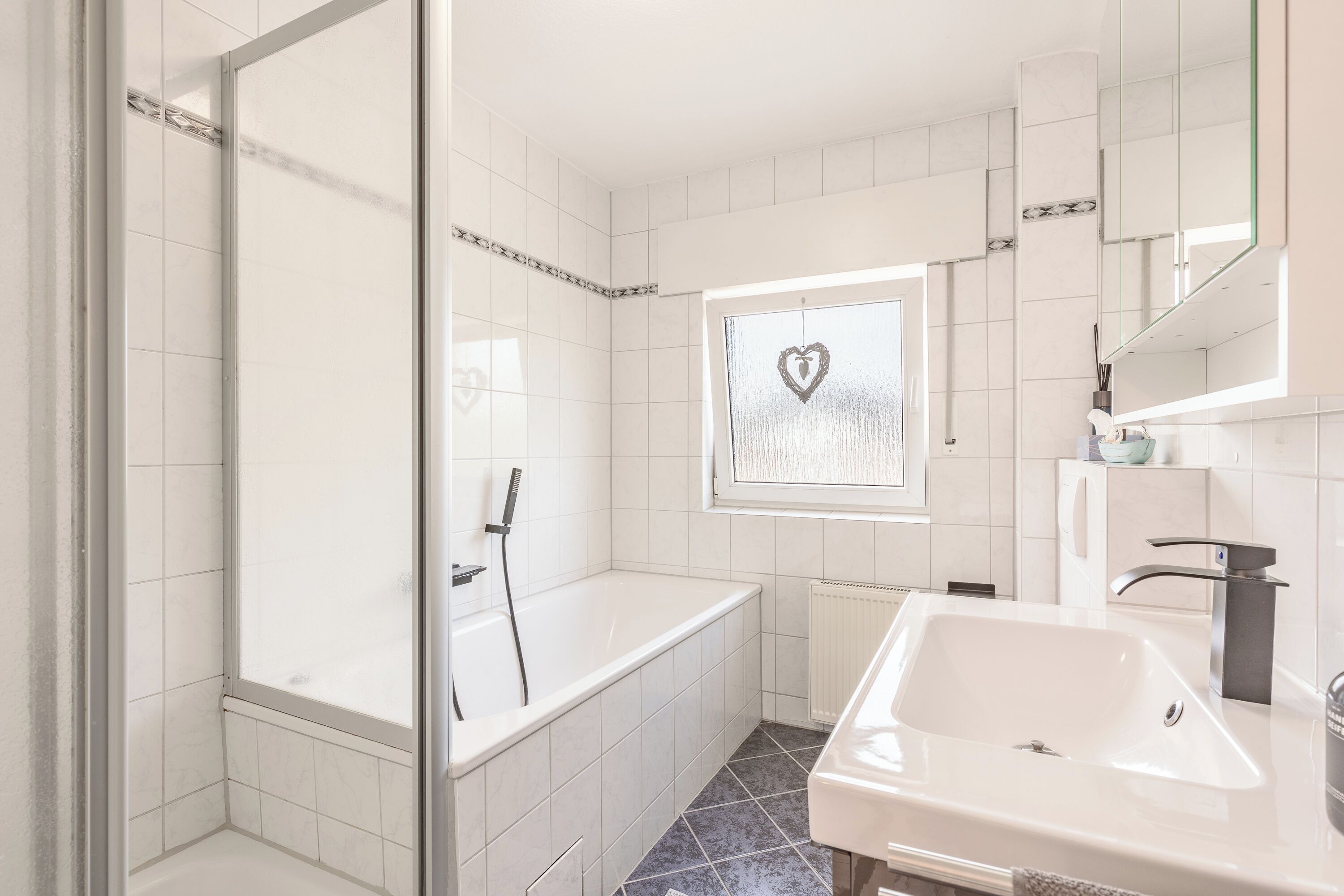 Un bagno moderno con vasca, doccia e lavabo.