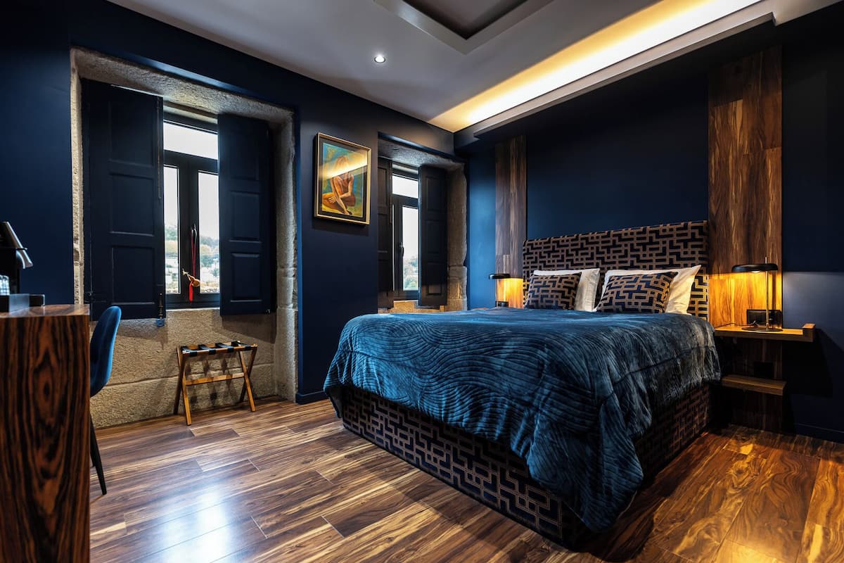 Un dormitorio moderno con una cama grande, un escritorio y una ventana con vistas.
