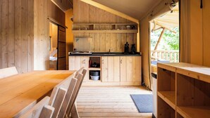 A wooden interior with a dining area, kitchen, and a view of the outdoors. - Arden Parks Signy L'Abbaye (Signy-l'Abbaye)