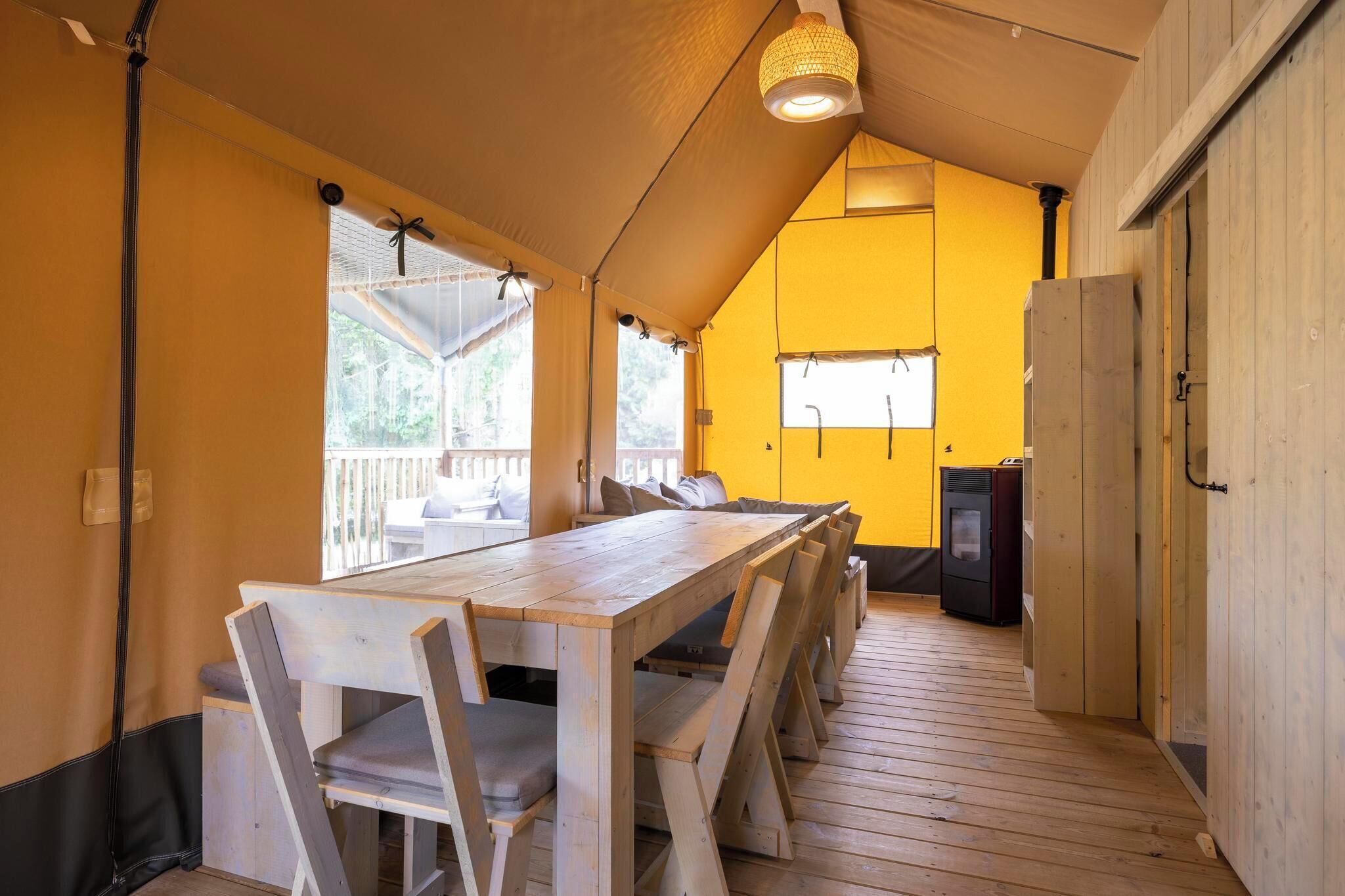 Ein Holzespeisezimmer mit Stühlen, eine Küchenzeile mit Kühlschrank und eine gelbe Wand.