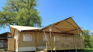 A camping site with a tent, a wooden deck, and a tree in the background. - Arden Parks Signy L'Abbaye (Signy-l'Abbaye)