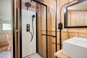 A wooden-paneled bathroom with a shower, a white sink, and a mirror. - Arden Parks Signy L'Abbaye (Signy-l'Abbaye)