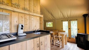 A wooden interior with a kitchen area, including a stove, coffee maker, and wooden cabinets. - Arden Parks Signy L'Abbaye (Signy-l'Abbaye)