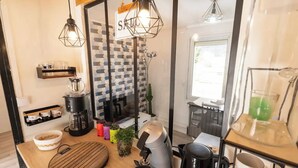 A modern kitchen with a coffee maker, kettle, and blender on the counter, a wooden cutting board, and hanging pendant lights. - Entire apartment - Saint-Dié-des-Vosges, France  (Saint-Dié-des-Vosges)