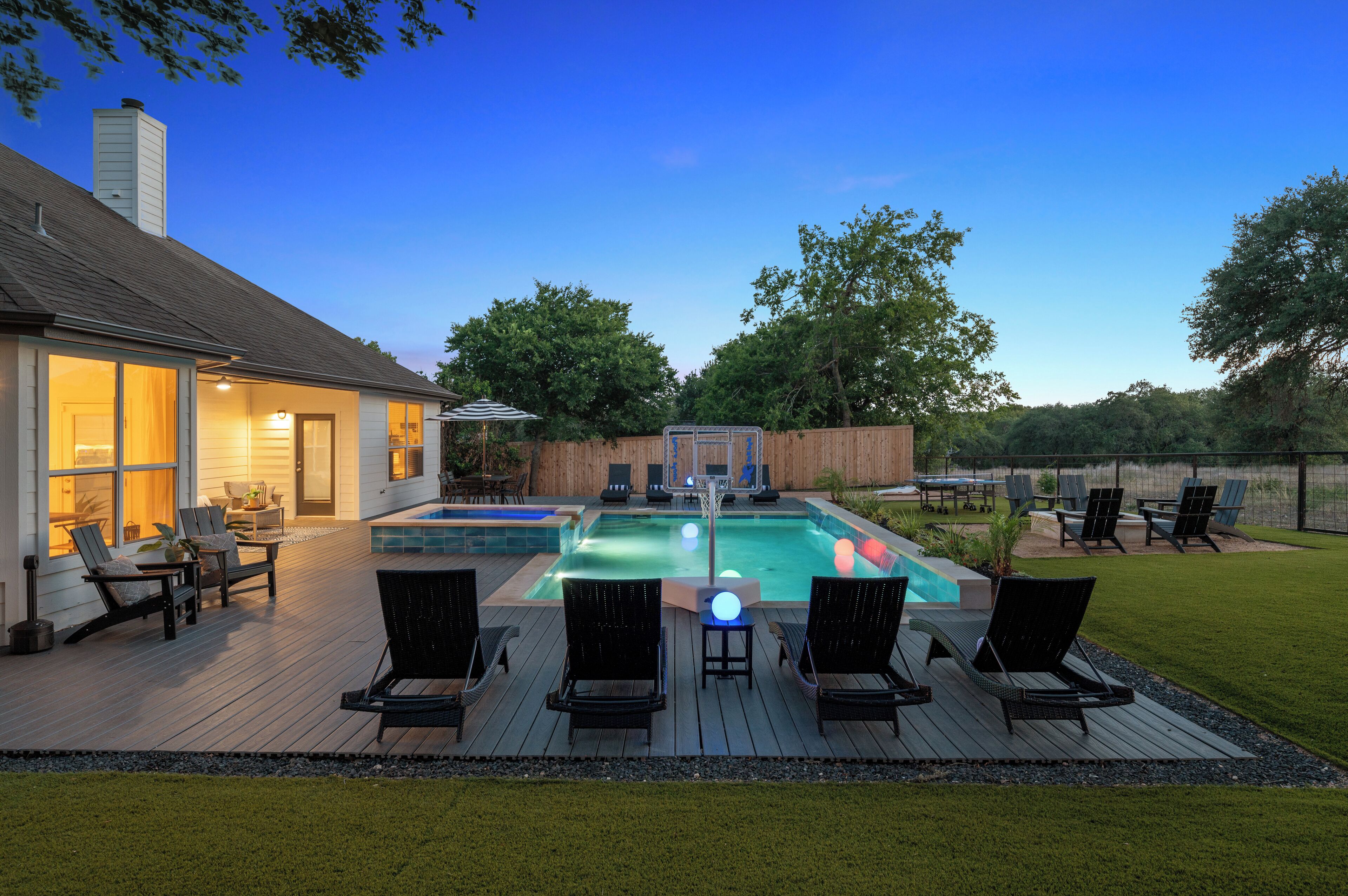 En have med swimmingpool, liggestole og et hus.