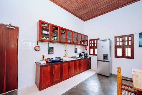 Una cocina con armarios de madera, un refrigerador y una estufa.