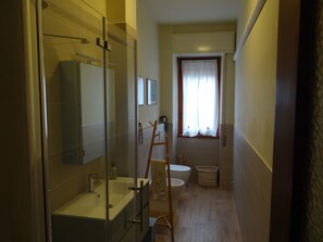 A narrow bathroom with a glass shower enclosure, a sink, and a toilet. - Viadanteunovigevano - 200 meters from Piazza Ducale (Vigevano)