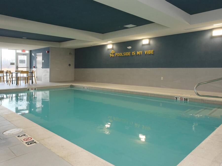 Ein Hallenbad mit einem Schild an der Wand, auf dem steht: "POOLSIDE IS MY VIBE".